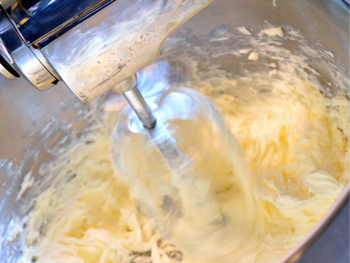 Homemade butter being whipped in stand-up mixer.