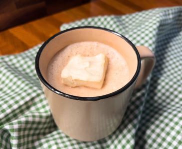 brown mug filled with hot cocoa and topped with a homemade marshmallow with a green and white checked towel in the background