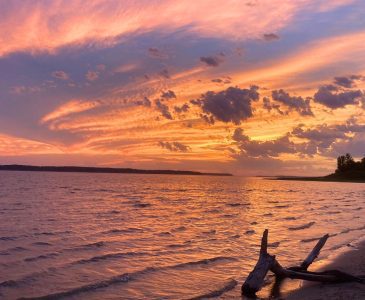 sunset over a lake with a beach