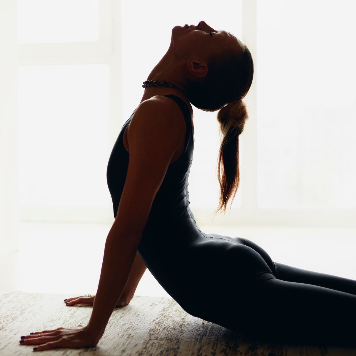 woman doing a cobra yoga pose while exercising like a minimalist