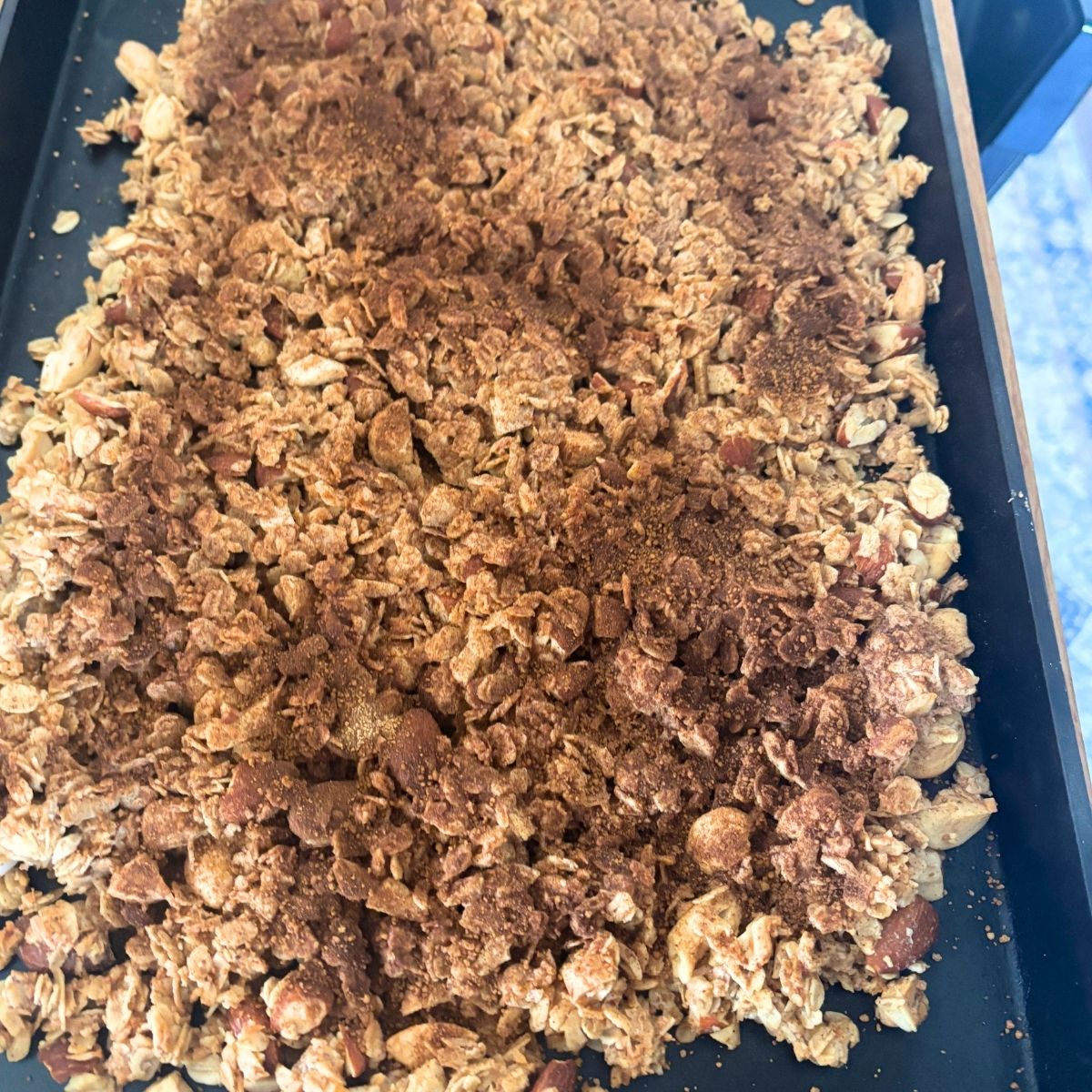 homemade cinnamon roll granola that has been baked on a cast iron baking sheet