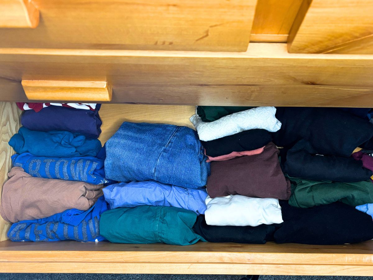capsule wardrobe in a wooden dresser drawer looking from over the top of the drawer