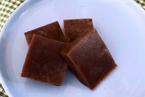 four homemade beef gelatin gummy candy squares on a light blue plate