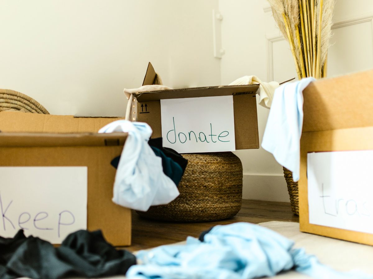 creating a capsule wardrobe with three boxes labeled keep donate and trash